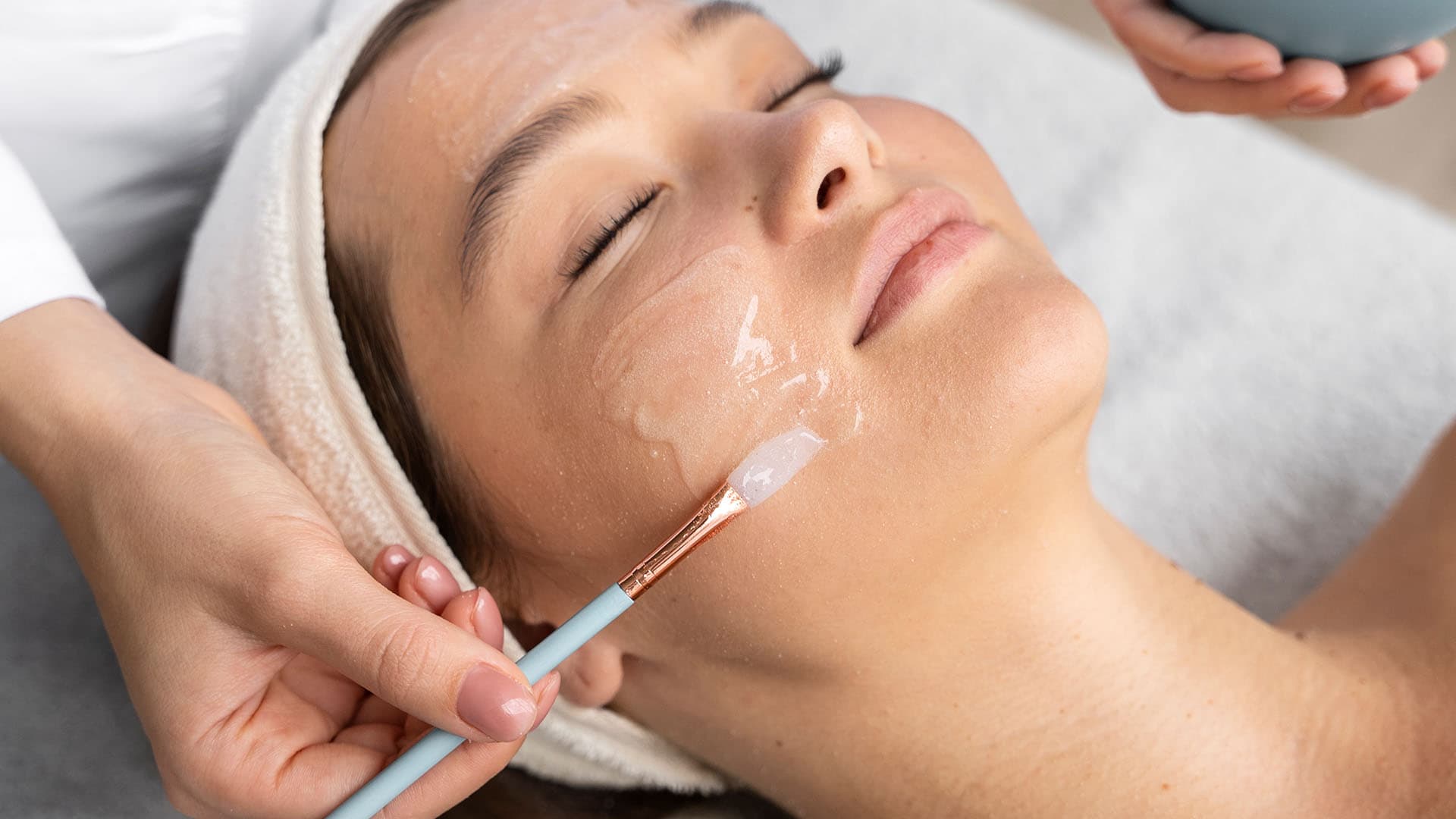 Chemical peel solution being brushed onto a patient's cheek