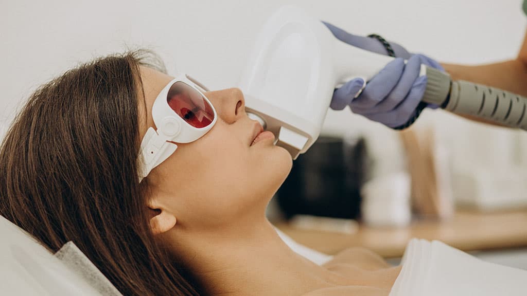 Patient in protective eyewear receiving a laser skin resurfacing treatment