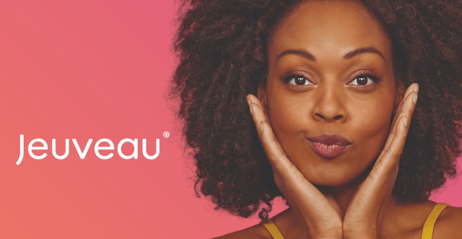 Smiling woman from the Jeuveau campaign resting her face on her hands