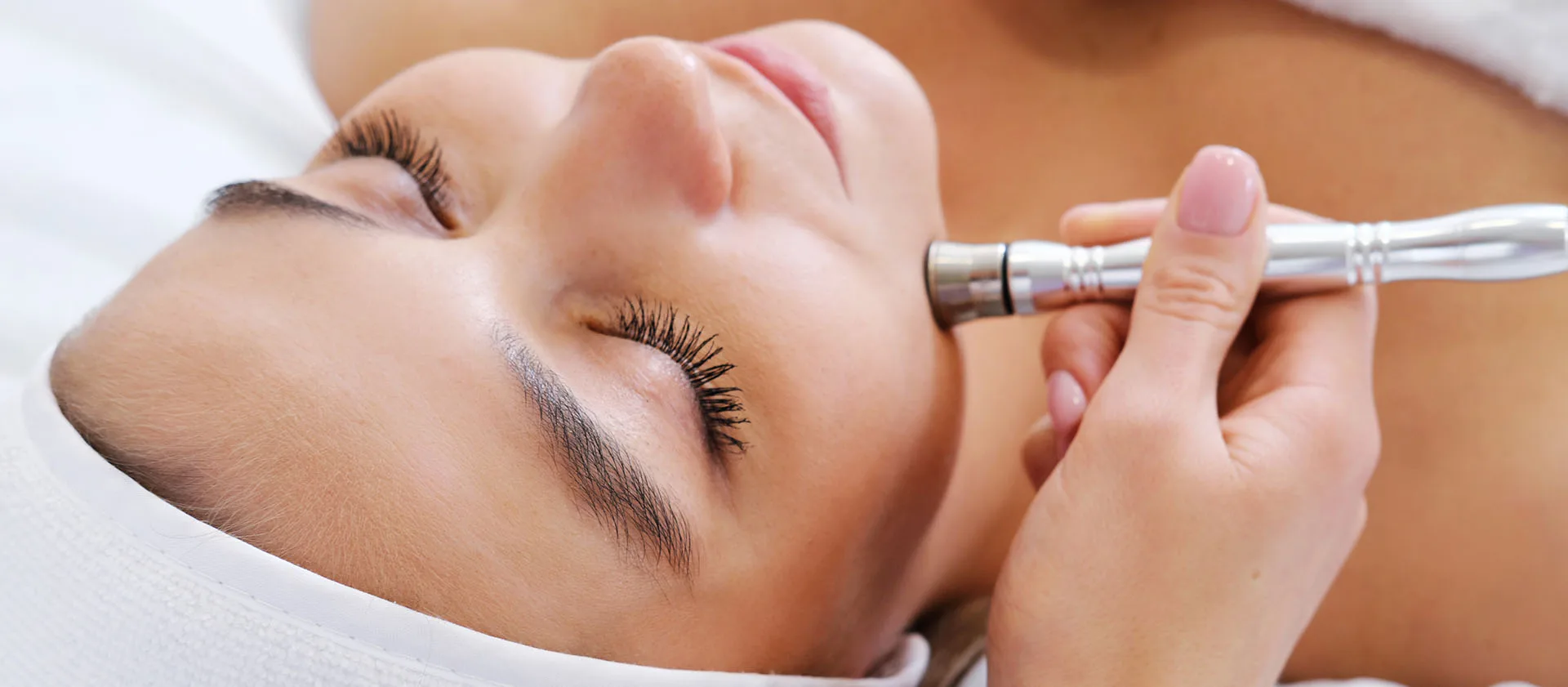 Diamond-tip microdermabrasion wand exfoliating a patient's cheek