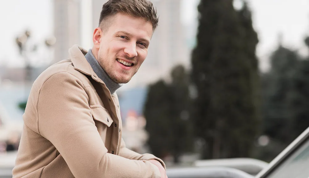 Smiling man in his thirties standing outdoors