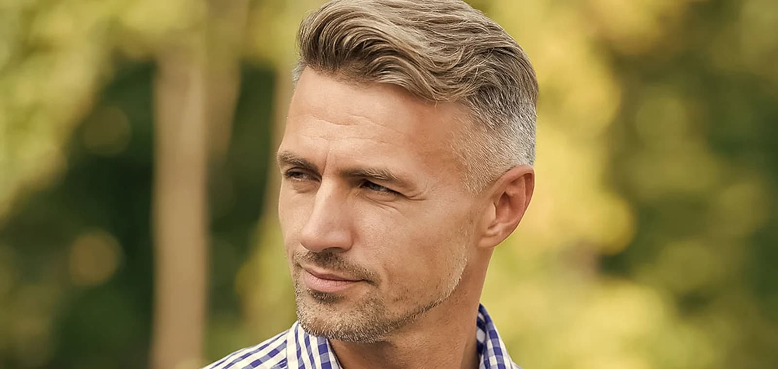 Man in his forties outdoors with a full, natural hairline, turned in profile